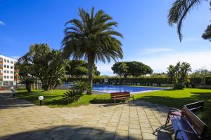 a park with benches and palm trees and a pool at Galera 2 ONLY FAMILIES Planet Costa Dorada in Cambrils