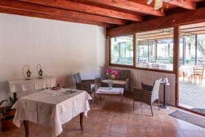 a dining room with two tables and chairs and windows at Il Falconiere in Muravera