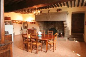 een eetkamer met een tafel en een open haard bij Le Logis d'Equilly in Équilly