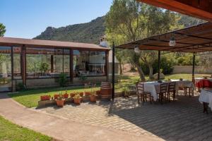 a patio with a table and chairs and a house at Il Falconiere in Muravera