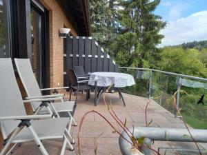 eine Terrasse mit einem Tisch und Stühlen auf dem Balkon in der Unterkunft Ferienwohnung Mossauer Höhe in Mossautal