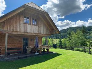a log cabin with a porch and a lawn at Pichelhütte in Murau