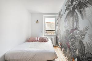um quarto com uma cama com um mural de palma na parede em Le Coco - Duplex proche mer em Cancale