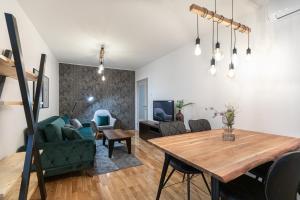 uma sala de estar com uma mesa e um sofá em Live & Sleep em Novi Sad