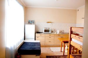 a small kitchen with a refrigerator and a table at Sun Shine Apartments in Jūrmala