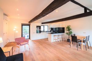 een keuken en een woonkamer met een tafel en stoelen bij The Main Square Residence in Antwerpen