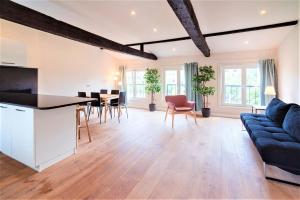 an open kitchen and living room with a blue couch at The Main Square Residence in Antwerp