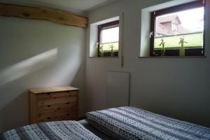 a bedroom with a bed and two windows at Wohlfühloase Rudolf in Dinkelsbühl