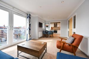 a living room with a couch and a table at Troon Executive Apartment in Troon