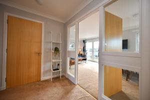 pasillo con puerta de madera y sala de estar en Troon Executive Apartment, en Troon