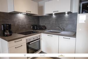 a kitchen with white cabinets and a sink at MARMOTTE 101 - Appartement pour 6, aux pieds des pistes in Bonneval-sur-Arc