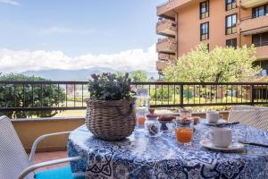 una mesa con un mantel azul y blanco en el balcón en House Samantha Lago Maggiore, en Laveno-Mombello