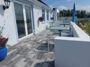 patio ze stołem i krzesłami na domu w obiekcie Rest a While w mieście Bushmills