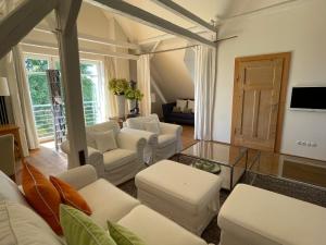 a living room with white furniture and a glass table at Landhaus am Rheinsteig & Loreley in Lykershausen