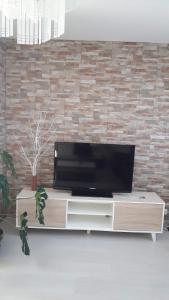 a flat screen tv sitting on top of a wooden entertainment center at Ático vacacional in Muros
