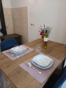 uma mesa de madeira com dois pratos e copos em Apartment Paolo em Sibenik