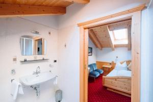 a bathroom with a sink and a bed in a room at Residence Alpenrose in Rasùn di Sotto +50 photos