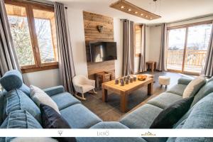 a living room with a blue couch and a table at MARMOTTE 102 - Beau T4 pour 10, aux pieds des pistes in Bonneval-sur-Arc