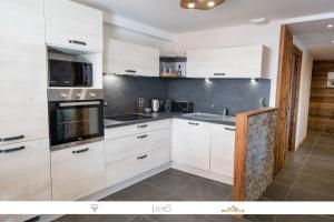 a kitchen with white cabinets and a sink at MARMOTTE 102 - Beau T4 pour 10, aux pieds des pistes in Bonneval-sur-Arc