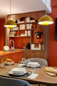 a kitchen with a wooden table with chairs and yellow lights at RockyPop Flaine Appartements & Spa in Flaine