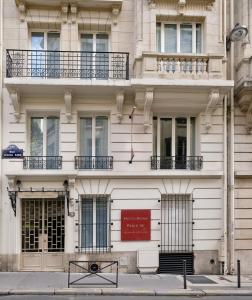 a white building with a red sign on it at HotelHome Paris 16 in Paris