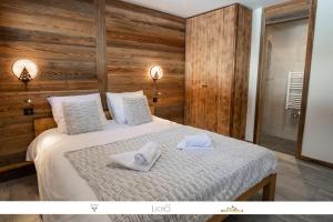 a bedroom with a bed with towels on it at MARMOTTE 102 - Beau T4 pour 10, aux pieds des pistes in Bonneval-sur-Arc