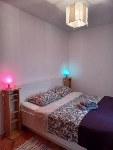 sypialnia z łóżkiem i nocną szafką z lampką w obiekcie Apartment Paolo w Szybeniku