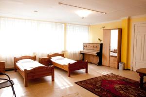 a living room with two beds and a piano at Sun Shine Apartments in Jūrmala