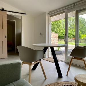 een woonkamer met een tafel en 2 stoelen bij Overnachting Vanjewelste in Enschede