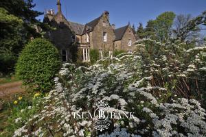 a garden with white flowers in front of a house at Isla Bank House in Keith