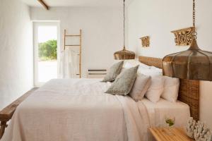 een slaapkamer met een groot bed met witte lakens en kussens bij Rufino Quinta in Estevais
