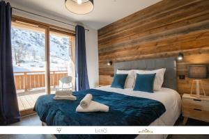a bedroom with a bed with a wooden wall at MARMOTTE 003 - Superbe T4 aux pieds des pistes in Bonneval-sur-Arc
