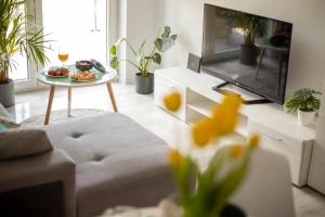 a living room with a couch and a table with food on it at Apartament Laurowa in Tyczyn