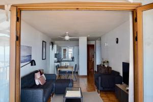 a living room with a couch and a table at Perla de Roca en Poblado Marinero in Acantilado de los Gigantes