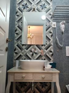 A Cantunera LittleHouse في أغريغينتو: حمام مع حوض ومرآة على الحائط