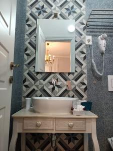 a bathroom with a sink and a mirror on a wall at A Cantunera LittleHouse in Agrigento