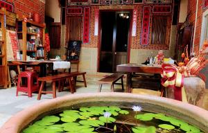 a pond filled with green lily pads in a room at 金門后倉七號新古厝民宿 in Jinning