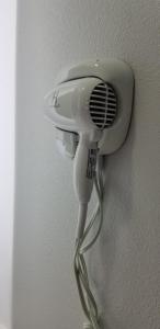 a white hairdryer hanging on a wall at DAY N NIGHT INN - Near Universal Studios Hollywood in Los Angeles