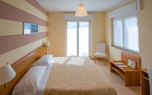 a bedroom with a large bed and two windows at Hotel Alpi in Baveno +25 photos
