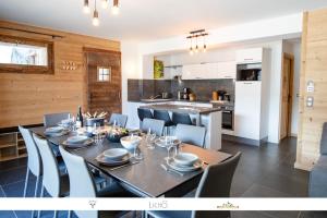 a dining room with a table and chairs and a kitchen at MARMOTTE 001 - Bel appartement avec grande terrasse, aux pieds des pistes in Bonneval-sur-Arc
