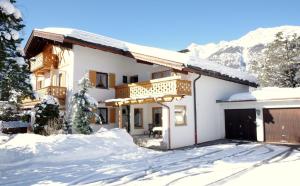 uma casa na neve nas montanhas em Gästehaus Lödermann em Garmisch-Partenkirchen