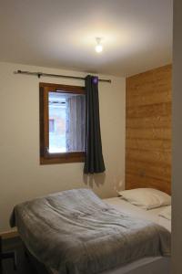 1 dormitorio con 1 cama con ventana y 1 cama doble en MARMOTTE 001 - Bel appartement avec grande terrasse, aux pieds des pistes en Bonneval-sur-Arc