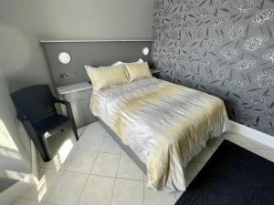 a small bedroom with a bed and a chair at Number 53 in Girvan