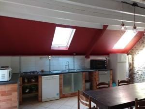 a kitchen with two skylights and a table in it at Domaine du Haul - Gîte Le Pressoir in Catteville +6 photos