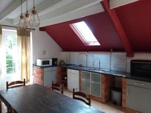 a kitchen with a table and a kitchen with a window at Domaine du Haul - Gîte Le Pressoir in Catteville