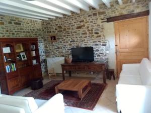 a living room with a couch and a tv at Domaine du Haul - Gîte Le Pressoir in Catteville