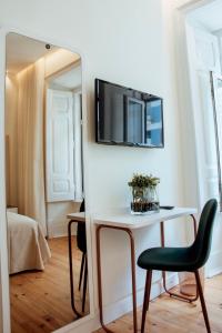 a mirror in a room with a table and a chair at Le Premier Lisbon Suites in Lisbon