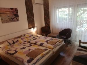 ブクにあるAnita Apartmanの毛布がかけられたベッドのある寝室 +31枚の写真