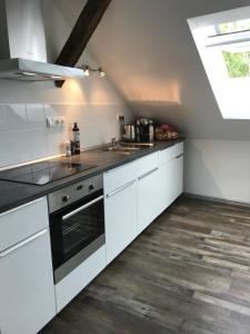 una cocina con armarios blancos y fregadero en Apartmán 3KK 80 m2 s vířivkou a saunou, en Jihlava