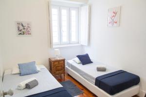 sypialnia z 2 łóżkami i oknem w obiekcie Guest House Amoreiras w Lizbonie